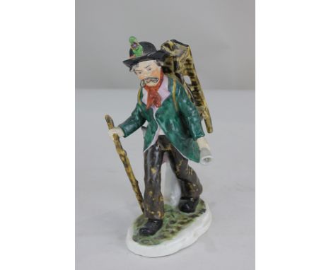 A German Pressig (Bavarian) porcelain figure of a hawker with bell and stick, 21cm high