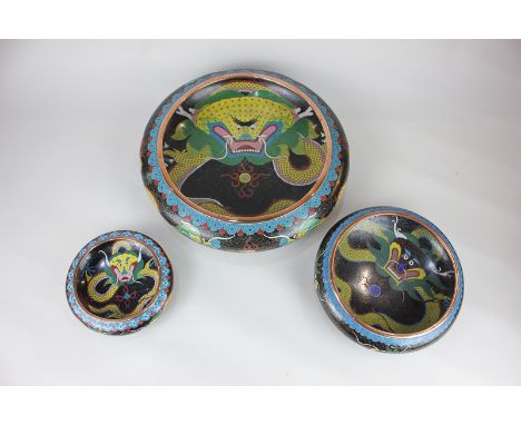 Three Japanese cloisonne enamel bowls decorated with sinuous yellow dragons, two with character marks to base, largest 30cm