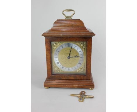A Georgian style walnut cased mantel clock, the dial and movement stamped Garrard, the square face with gilt spandrels and Ro