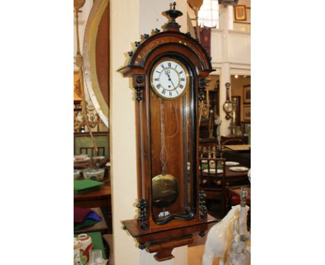 A reproduction mahogany Vienna style wall clock with five inch white enamel dial, Roman numerals, in arched glazed case, with