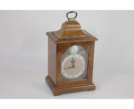 A reproduction mahogany cased mantel clock with plaque 'Tempus Fugit, Rotheram' and gilt foliate and mask spandrels, the chap