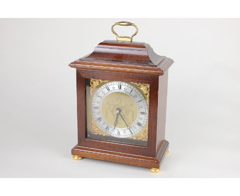 A reproduction Georgian style bracket mantel clock with brass carry handle, battery operated movement, 25cm high