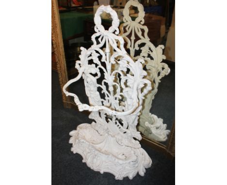 A Coalbrook style white painted aluminium umbrella and stick stand, the bow and floral scroll design around two figural suppo