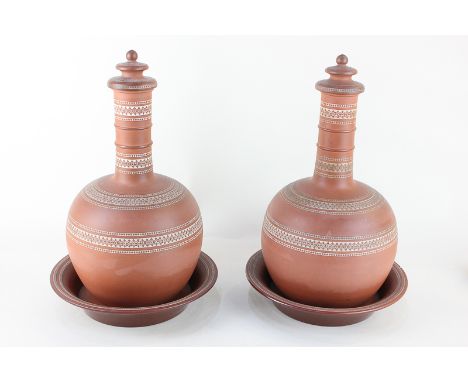 A pair of terracotta flasks and covers, of baluster form, with stands/saucers, decorated with white geometric borders, stampe