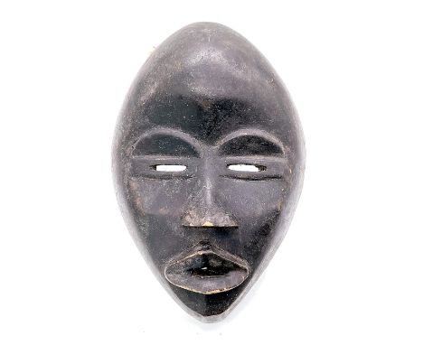 All black mask with slit eyes and protruding lips and nose. Domed forehead tapers to a pointed chin.Style is similar to dan m