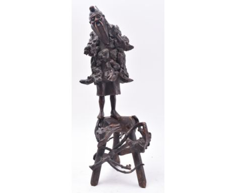 A 19th century Japanese carved root wood figure of a fisherman. The carving stood upright with rod on one hand and fish in th