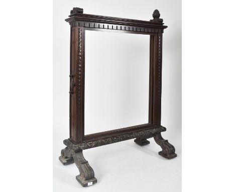A grand sized 19th century Victorian mahogany large framed fire screen. The screen with pineapple finals atop with carved den
