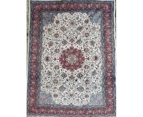 An early 20th century North West Persian Islamic Sarouk hand woven floor carpet rug having a central floral red medallion ins