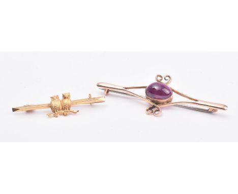 Two 9ct gold brooch pins. The first in a scrolling crossover design having an oval cut garnet set to the centre on a C clasp 