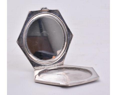 A hallmarked silver compact mirror. The mirror of post war Art Deco style in hexagonal form with stepped and engine turned de