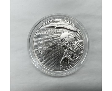 The obverse side depicts a fighter jet pilot flying along side a F-22 fighter jet. The reverse side depicts the three spires 