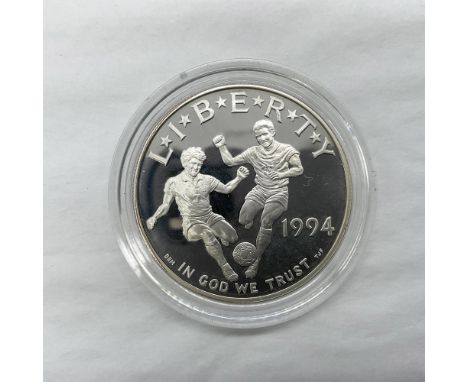 San Francisco Mint. The obverse side depicts two soccer players competing for the ball. The reverse side features the World C