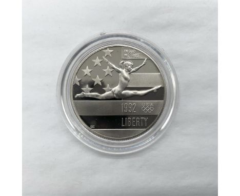 San Francisco Mint. The obverse side depicts a gymnast preforming in front of the American flag. The reverse side features an