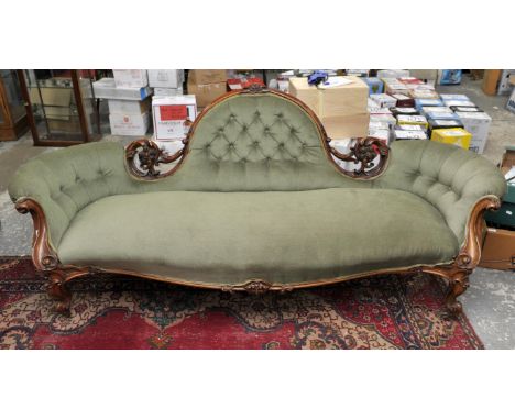 Victorian walnut sofa, with carved foliate and floral back rail, scrolling arms, on cabriole legs with brass casters, upholst