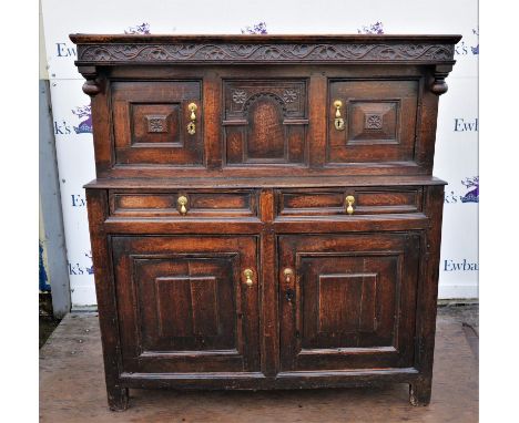Oak buffet, 18th/19th Century, the top with trailing branch frieze, above central architectural and flowerhead panel, flanked