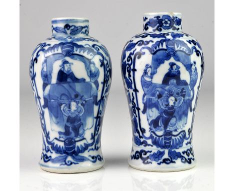 Matched pair of Chinese blue and white vases decorated with two panels of figures framed by scrolling flowers and foliage, ea