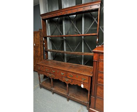 Oak dresser, 18th Century, with a two tier pot rack, the base with three frieze drawers above short drawers, on turned legs j