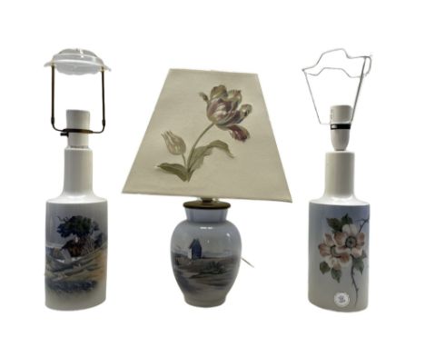 Three Royal Copenhagen lamps comprising two shouldered cylindrical form lamps decorated with a Danish landscape and the other