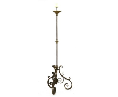 A wrought iron floor-standing pricket candlestick,in the 17th century style, with an ornately scrolled triform base,180cm hig