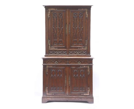 A French Gothic oak cabinet,mid-19th century, the top section with two blind fret carved panelled doors and ornate cast metal