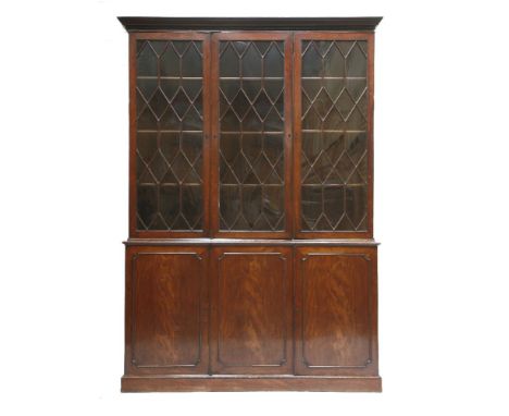 A George III mahogany bookcase,the moulded cornice over a dentil frieze and three astragal glazed doors, the base with three 