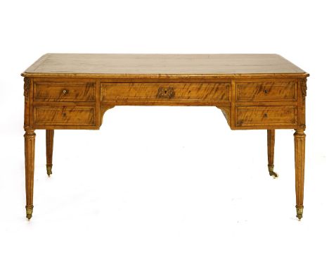 A satinwood desk, late 19th century, the shaped top over a central frieze drawer flanked on each side by two drawers, the cor