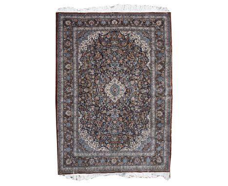 A large hand-knotted Persian carpet,20th century, the blue and biscuit fields with all-over foliate decoration within a wide 