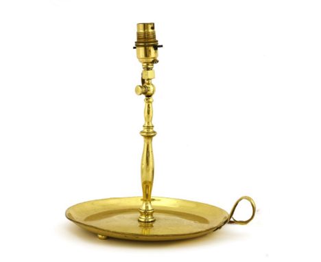 An Arts and Crafts brass table lamp,c.1900, in the form of a chamber candlestick, with a 23cm diameter base and adjustable bu