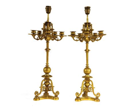 A pair of ormolu table lights,each in the form of six-light candelabra with scrolling decoration, on scrolling legs and a tri