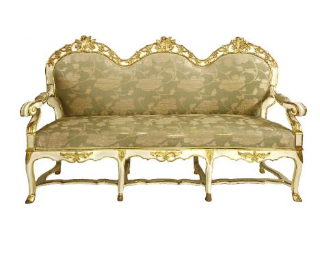 A Swedish Empire sofa,19th century, the humped back top rail decorated with carved and gilded leaves and flower heads, the ou