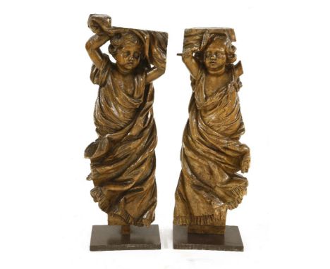 Two carved limewood cherubs,probably 17th century, north European, each standing with arms aloft, dressed in flowing robes on