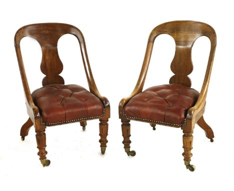 A pair of William IV rosewood low chairs, each with a shaped splat back over a button upholstered seat, with turned and carve