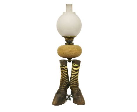 A zebra hoof oil lamp,early 20th century, the pottery basket weave moulded reservoir raised on a brass platform and four zebr