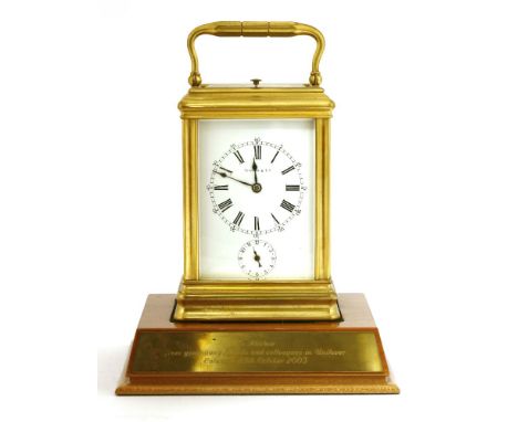 A Tiffany brass alarm repeat carriage clock, with white enamel dial and black Roman numerals, the movement striking on a gong