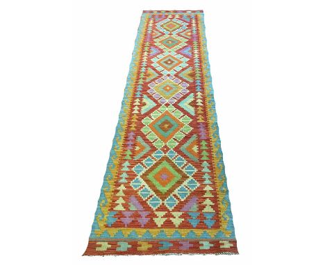 ANATOLIAN KILIM RUNNER, 300cm x 78cm, of multiple polychrome medallions, on terracotta field.