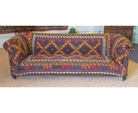 CHESTERFIELD SOFA, Victorian ebonised in Kilim upholstery with brass castors, 235cm W.