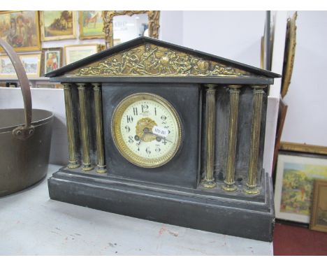 A XIX Century Black Slate Mantel Clock, brass pediment, decorated with figures, circular dial, brass column supports, stepped