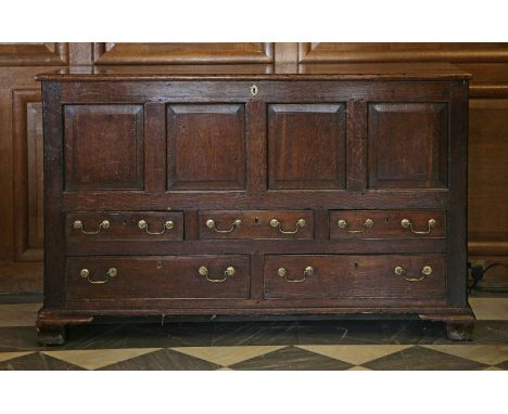 A four-panel oak mule chest,18th century, the rising lid above an arrangement of three small and two large cock-beaded drawer