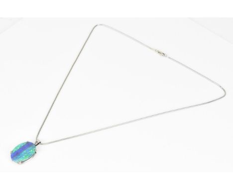 An 18ct white gold mounted boulder opal doublet pendant, the oval stone in a double claw setting, on a white metal snake chai