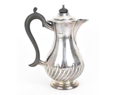 An Edwardian silver hot water pot by James Deakin &amp; Sons, Sheffield 1910, of baluster form with part fluted lower part, e