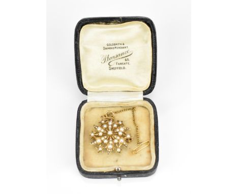 An Edwardian 15ct yellow gold and pearl starburst brooch, 3 cm diameter, the back with revolving catch and safety chain, weig