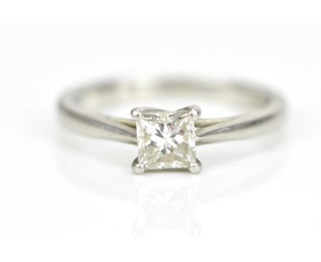 A platinum and diamond engagement ring, set with a central square modified brilliant cut stone in a four claw setting, 0.5 ca