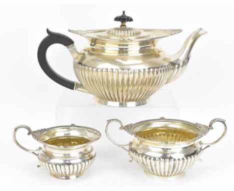 A George V silver three piece tea set by Walker &amp; Hall, Sheffield 1917, comprising a teapot, twin-handled sugar pot and m