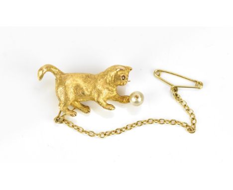 An 18ct yellow gold, diamond and pearl brooch of a cat playing with a ball, naturalistically modelled with textured body, the