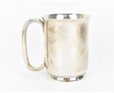 A Victorian silver tankard by George Unite, Birmingham 1886, of plain form with everted rim, hoop handle, on a footed base wi