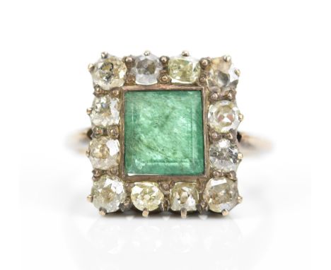 A diamond and emerald cocktail ring, with central square step cut emerald in a halo of twelve mixed old cut diamonds, on a me