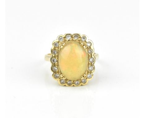 A yellow metal, diamond and fire opal dress ring, set with central cabochon opal in a halo of eighteen brilliant cut diamonds