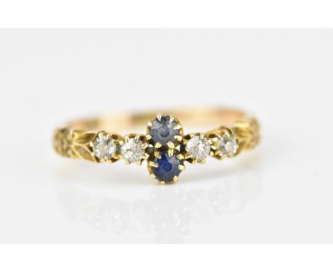 An Edwardian 18ct yellow gold, diamond and blue sapphire dress ring, with central two round cut sapphires flanked either side