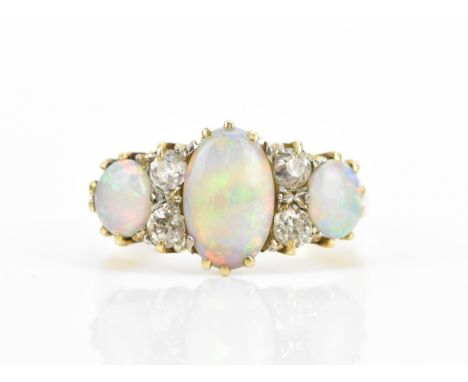 An Art Deco 18ct yellow gold, platinum, diamond and crystal opal dress ring, set with a central oval cabochon opal flanked wi