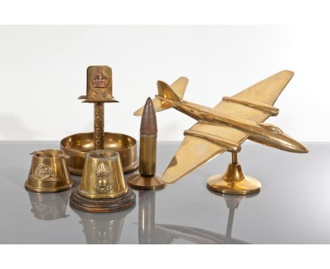 FIVE TRENCH ART ITEMS
including three brass shell ash trays, a brass model plane and a lighter formed from a brass shell, pla